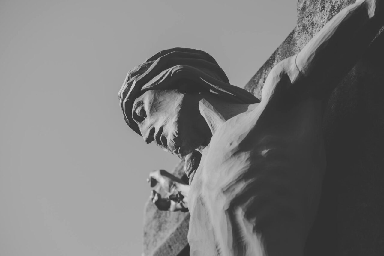 statue of crucified jesus christ in black and white